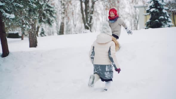 Cheerful Children are Running Through the Snow and Playing Together in the Park in the Winter