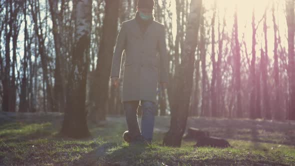 Handsome Man in Mask Holds Leash and Walks with Cute Puppy