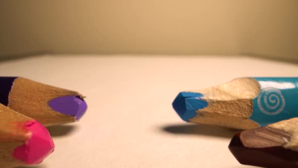 Camera Moves Above Rows of Colored Pencils. Wooden Pencils Lie Opposite Each Other in a Row. White