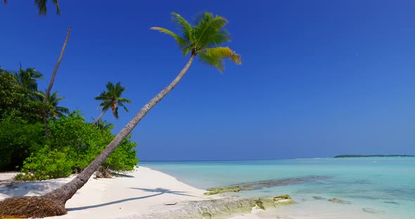 Wide aerial copy space shot of a sandy white paradise beach and blue water background in colourful 4