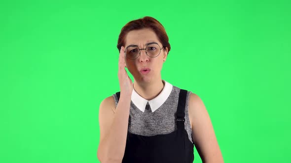 Portrait of Funny Girl in Round Glasses Is Listens Attentively While Sympathizing. Green Screen