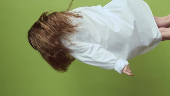 Girl With Long Hair Dancing On Background Of Light Green Wall