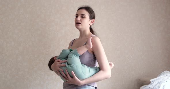 Tired Mother Holding Baby on Hands at Home