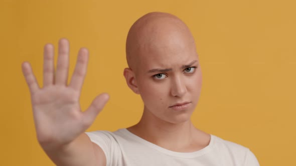 Hairless Woman Gesturing Stop Shaking Head Over Yellow Background