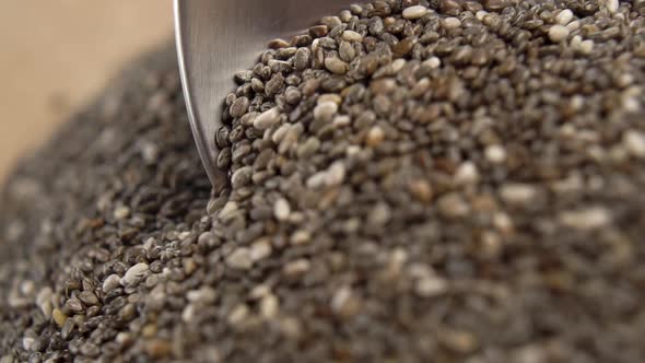 Moving spoon in a pile of chia seeds in extreme close-up