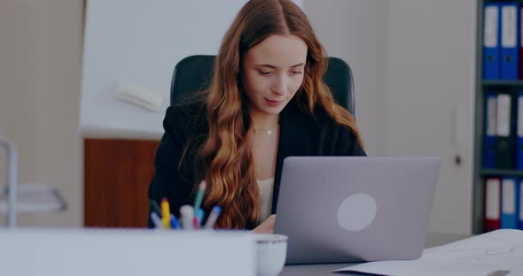 Tensed Businesswoman Working on Laptop in Office