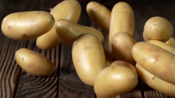 Super Slow Motion Shot of Potatoes Rolling on Old Wooden Table at 1000Fps