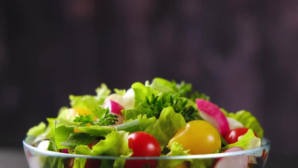 Fresh vegetable salad from cucumber, tomato and lettuce on black background