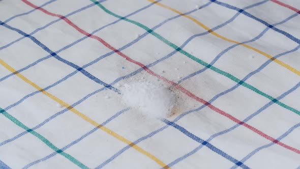 Pouring Washing White Powder on the Stain Closeup Putting Detergent on Spoiled Dirty on Checkered