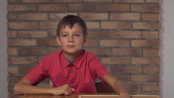 Child Sitting at the Desk Holding Flipchart with Lettering Day Off on the Background Red Brick Wall