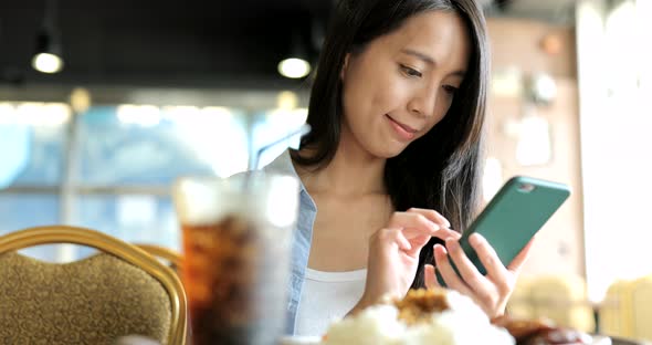 Woman looking at mobile phone in restaurant 
