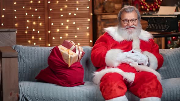 Handsome Male Santa Claus with Natural Beard Smiling Posing on Couch