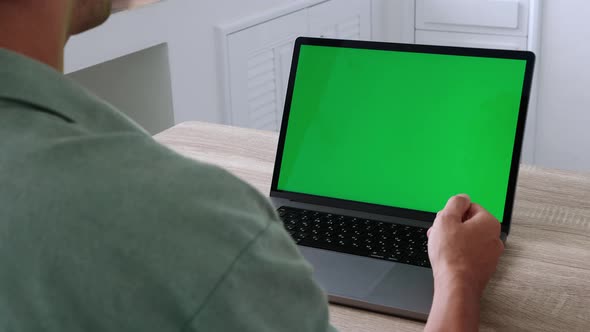 Closeup Back View Shoot of Young Business Man Having a Video Call on the Laptop with Green Chroma