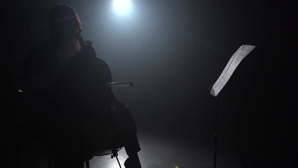 Playing the Cello in a Dark Room with a Lantern Next To the Music Stand