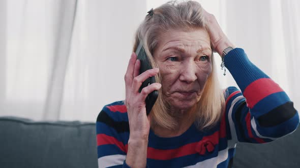 Desperate Old Woman Having Phone Conversation with Tears