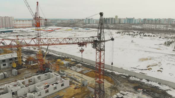 Orange Building Cranes on Construction Site Against Field