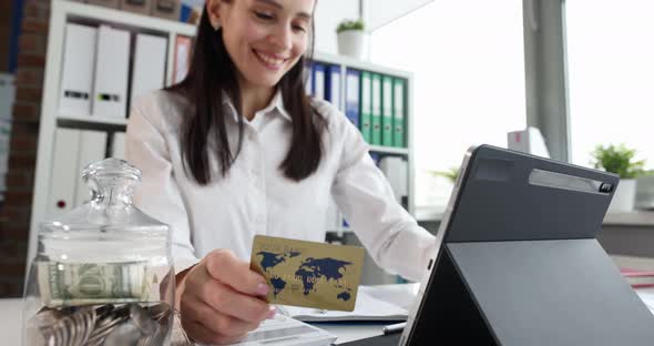 Smiling Woman Makes Payments on Internet with Bank Card