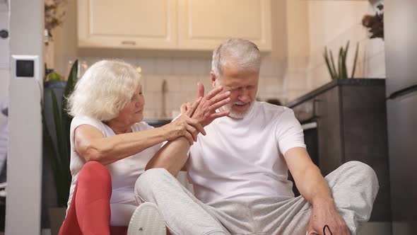 an Elderly Man Feels Bad After a Workout a Woman Supports and Helps Him They Sit on the Floor of the