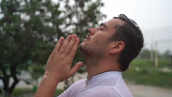 Young Religious Man Says a Prayer Standing Outside