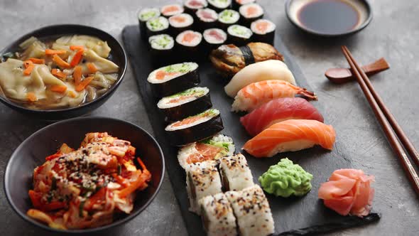 Composition of Different Kinds of Sushi Rolls Placed on Black Stone Board