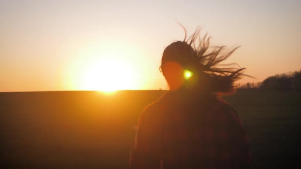 Young Woman Jogging at the Meadow and Enjoying Freedom at Sunset. Freedom Concept.