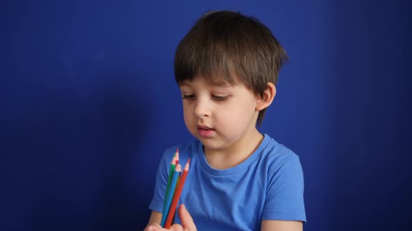 Child Sits at Home on a Sofa in a Blue T-shirt Plays at Home