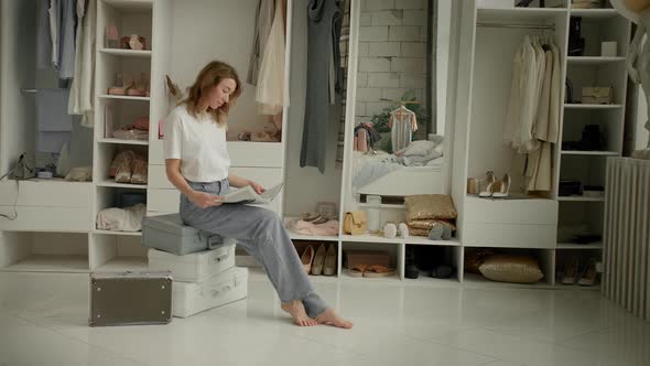 Girl Dreamily Reads a Magazine and Looks Out the Window