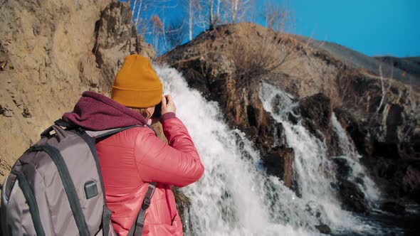 Woman Takes Photo of Waterfall