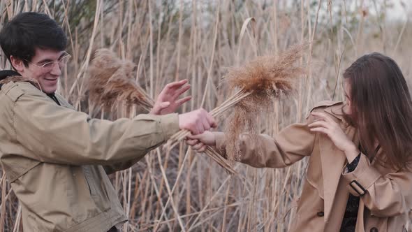 Couple Spends Time Outdoors Playing with Phragmites