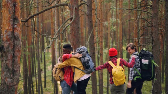 Friends Tourists Are Raising Hands and Laughing Standing on Top of Mountain Then Hugging Each Other