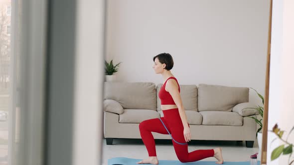The Woman Is Doing Butt Exercise with a Fitness Band