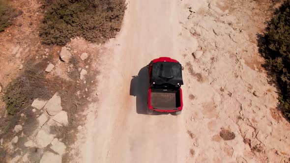 Close tracking shot looking down on a four wheeler dune buggy driving fast on a dirt road
