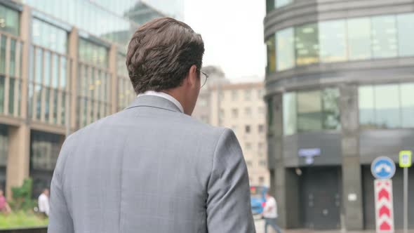 Back View of Businessman Walking on Street