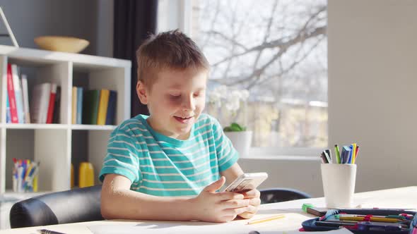 Boy is Doing  Homework at the Table. Cute Child is Learning at Home.