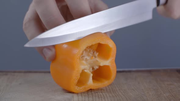 Chef Is Slicing Orange Bell Pepper on the Wooden Board, Cutting Vegetables, Cooking the Fresh Salad