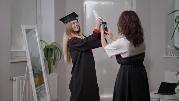 Medium Shot Portrait Happy Woman in Graduate Outfit Posing As Mature Mother Taking Photos on