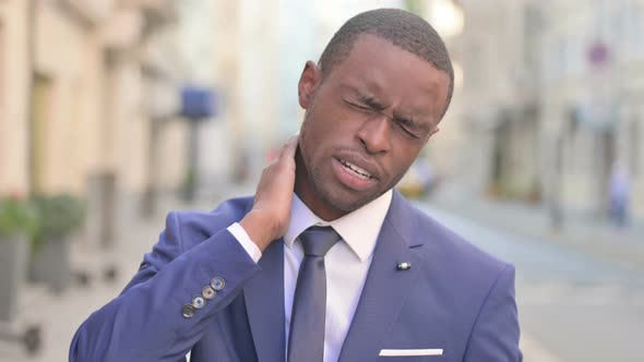 Outdoor African Businessman Having Neck Pain