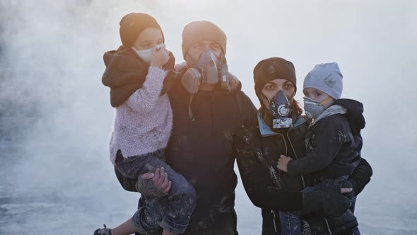 Portrait of survivor family in gas mask standing in clouds of toxic smoke and cinder