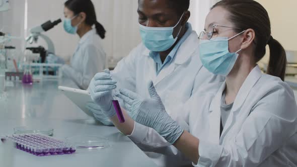 Slowmo of Scientists Inspecting Solution in Test Tube and Posing