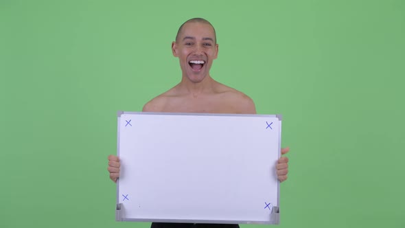 Happy Bald Multi Ethnic Shirtless Man Holding White Board and Looking Surprised