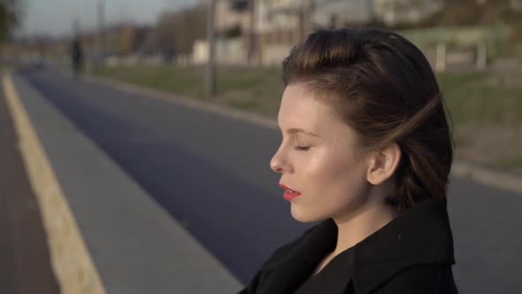 Profile Portrait of Passionate Lady with Red Lips Thoughtfully Looks Right Outdoors