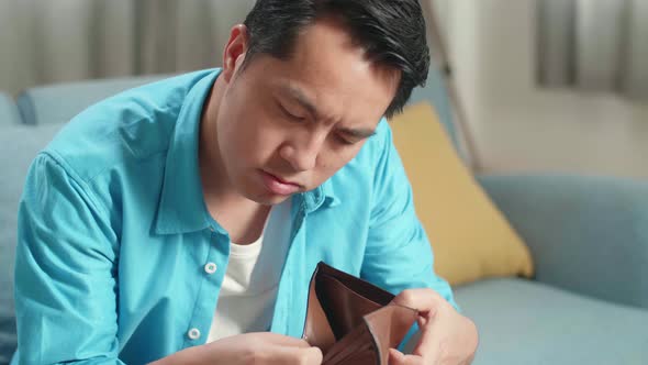 Close Up Of Asian Man With A Laptop Checking Money On The Wallet Before Shaking His Head