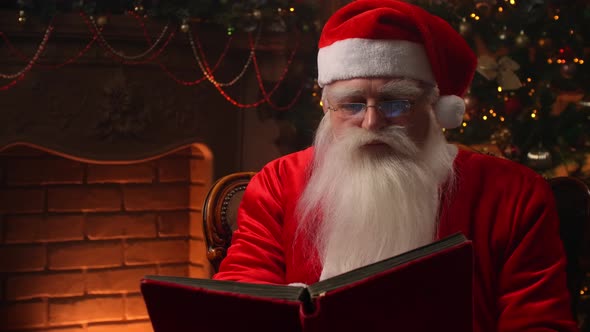 Santa Claus Sitting at His Room at Home Near Christmas Tree and Resting By His Fireplace.