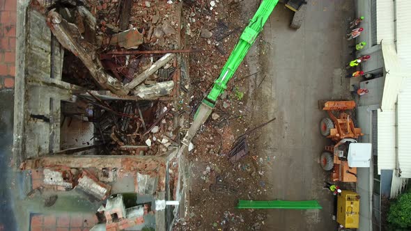 Aerial view above of workers dismantling a abandoned building, Cambodia.