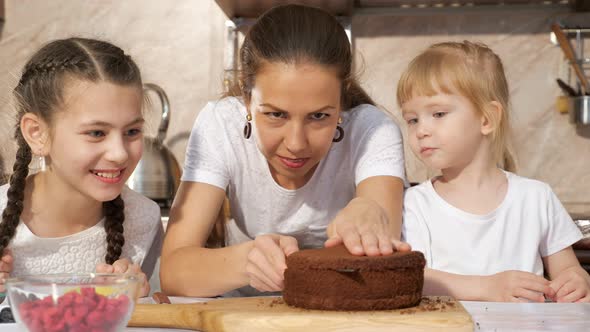 Happy Family Mom and Daughters Are Cooking Birthday Cake Together