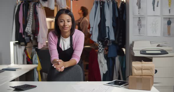 African Female Fashion Clothing Seller Looking at Camera in Workshop