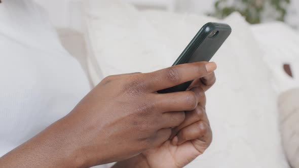 Closeup Young African American Woman Holding Cellphone in Hands Using Dating Application Scrolling
