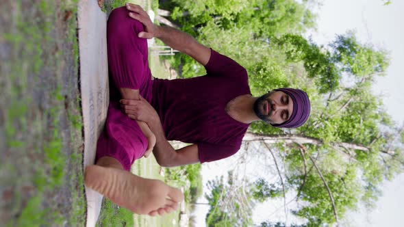 An Arabian Man Runs Yoga Classes Outdoors  Teaching How to Properly Put Legs in Lotus Position