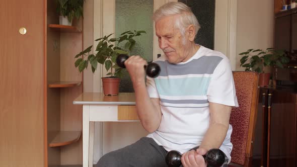 Senior Elderly Caucasian Man Doing Weight Lifting Dumbbell Exercising at Home