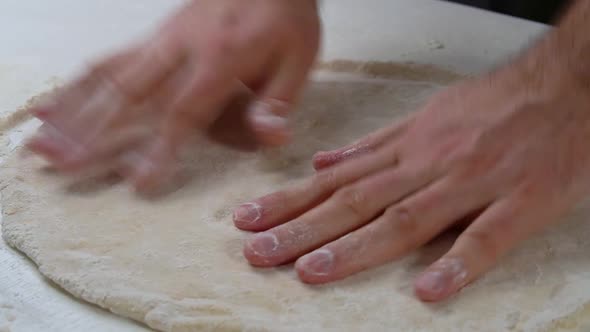 Professional Chef Stretches and Twists Soft Italian Pizza Dough with His Hands